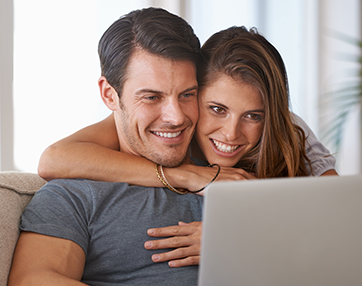 couple smiling looking at computer